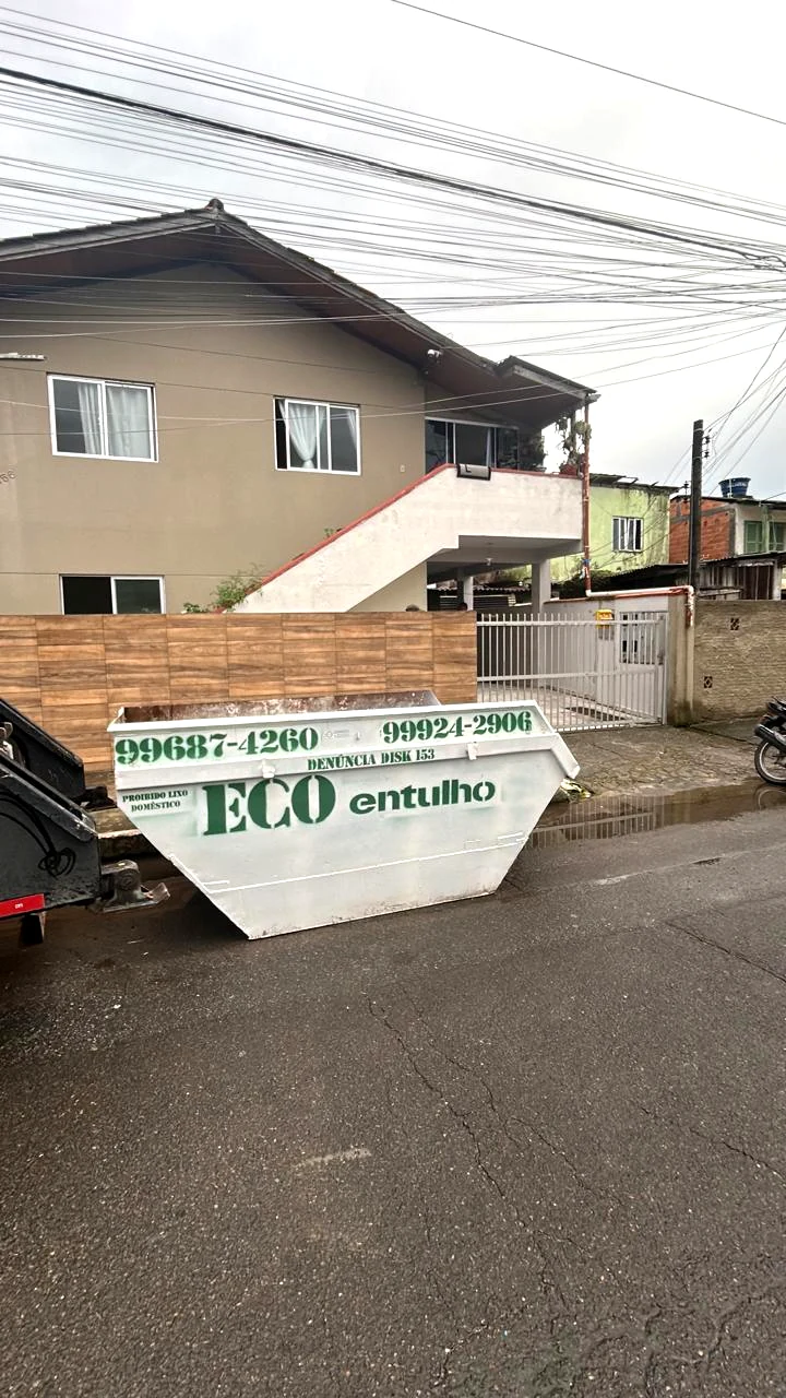 Caçamba de entulho branca da Eco Entulhos identificada em verde
