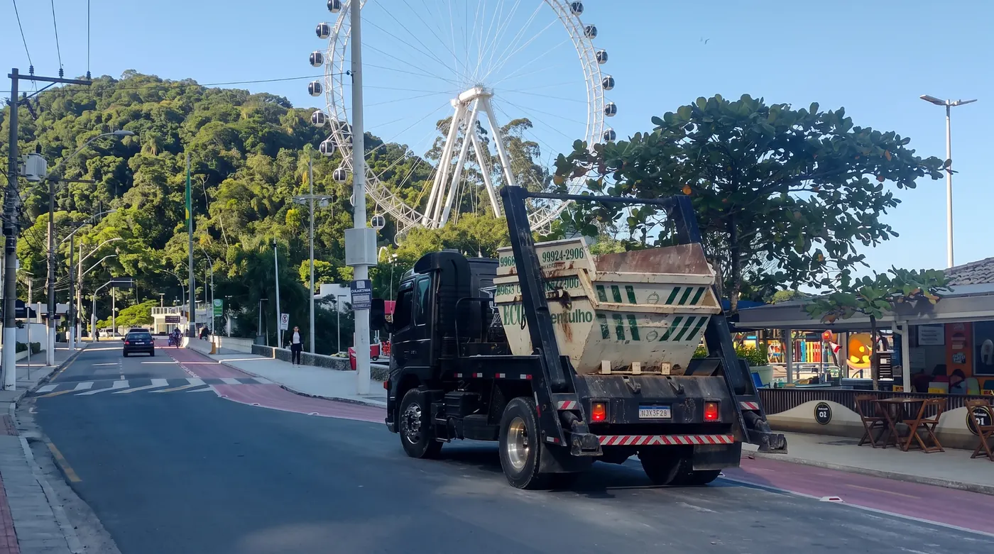Caminhão da Eco Entulhos transportando uma caçamba em via urbana